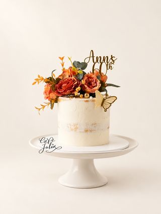 Ivory cake for Ann’s 60th birthday with orange flowers, gold butterfly, and a Café Julia watermark