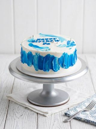 Round white cake decorated with painterly blue buttercream brushstrokes