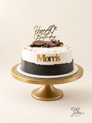 Black and white fortieth birthday cake with gold lettering and chocolate decorations